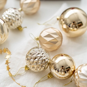 Boules de Noël dorées et champagne avec textures facettées sur fond en tissu de lin