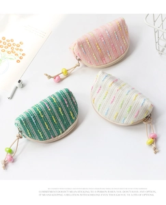 Detailed view of semi-circular woven mini purses in pink, green and cream textures