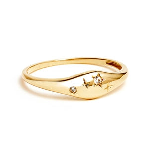 Macro view of 18K gold starburst ring with crystal inlay and vintage celestial engraving