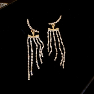 Detailed macro of gold drop earrings with sparkling rhinestone tassels on black background