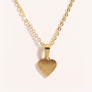 Detailed close-up of a gold heart pendant engraved with love you on a slim O-chain