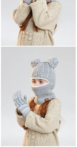 Detail of grey knitted balaclava with dual pom-poms and matching gloves for kids