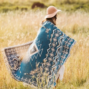 Close-up of bohemian woven picnic blanket with ethnic patterns and delicate fringe