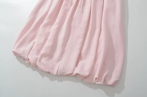 Gros plan détaillé de l'ourlet bulle rose clair et de la texture du tissu en mousseline