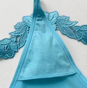 Macro shot of sky blue water-soluble lace embroidery and reinforced stitching details
