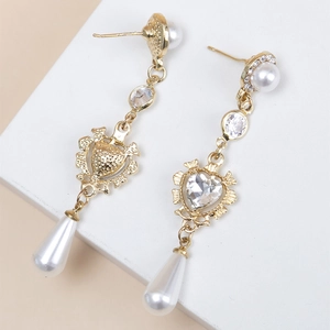 Detailed macro of baroque vintage earrings with heart zircon and long pearl drops