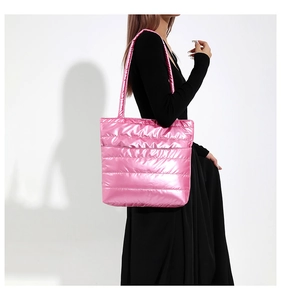 Close-up of metallic pink quilted tote bag with puffy down-like texture and long handles