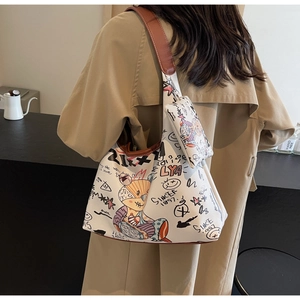 Détail du sac à bandoulière avec motifs ours graffiti et mini pochette assortie