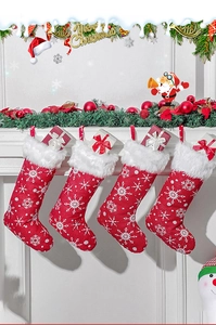 Detailed view of red plush Christmas stockings with white snowflake embroidery hanging on a mantel