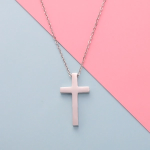 Polished silver stainless steel cross pendant necklace on a clean blue background
