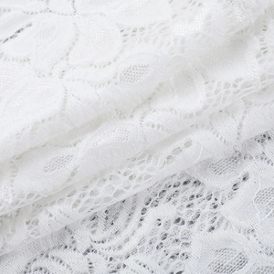 Gros plan sur le tissu en dentelle blanche avec broderie florale ajourée délicate