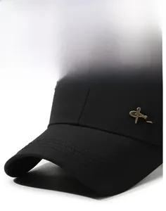 Detail of black baseball cap brim with metallic emblem and premium stitching