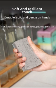 Close-up of flexible gray high-density cleaning sponge showing elastic rebound and porous texture