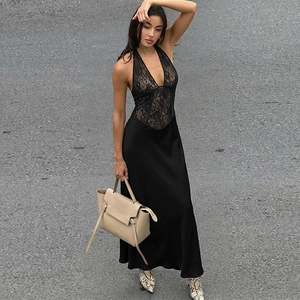 Close-up of black lace patchwork and smooth satin fabric on a deep V-neck dress