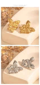 Macro view of textured metal butterfly earrings featuring fine vertical stripes