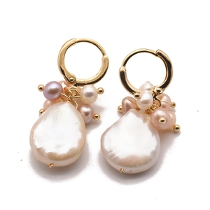 Elegant gold baroque pearl earrings with colorful cluster beads on a reflective surface