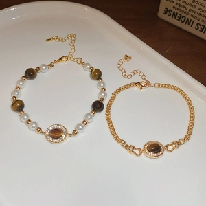 Détail des bracelets en œil de tigre avec perles et cristaux dans un plateau blanc