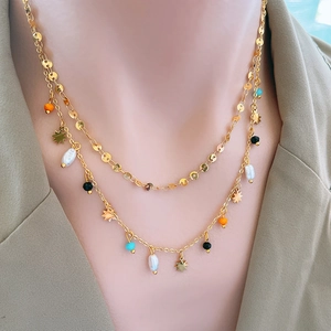 Layered 18k gold plated titanium necklace with pearl star and disc charms on model