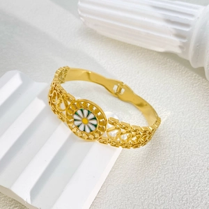 Macro shot of gold watch-style bangle featuring hollow heart patterns and a daisy charm