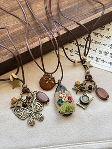 Detail of vintage wooden beads and bronze butterfly charms on handmade cord necklaces