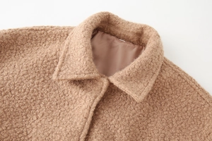 Macro detail of camel teddy wool jacket featuring textured fleece collar and smooth lining