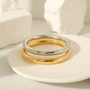 Minimalist 18K gold and silver polished stainless steel bangles on display