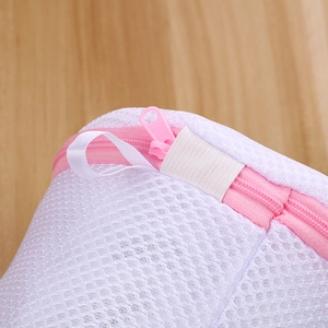 Detail of pink zipper and white elastic protective cover on a mesh laundry bag