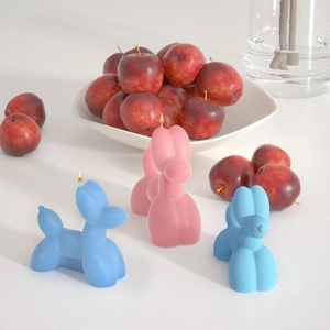 Modern balloon dog scented candles in matte pink and blue colors on a clean background