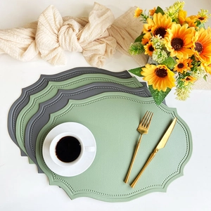 Faux leather placemats with wave edges in green and grey featuring a heat resistant surface