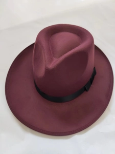 Top view of a burgundy wool fedora hat with a classic black ribbon on a white background