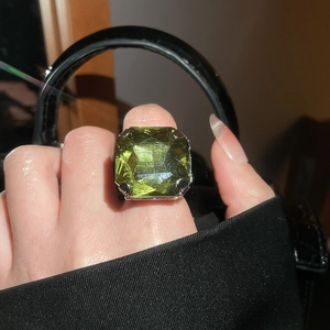 Macro detail of high-quality radiant cut green gemstone in silver four-prong setting