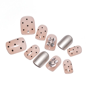 Short nude press-on nails featuring silver metallic finish, black dots, and rhinestones