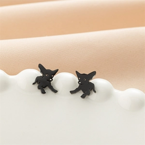 Vue macro de boucles d'oreilles chien noires minimalistes sur un plateau blanc