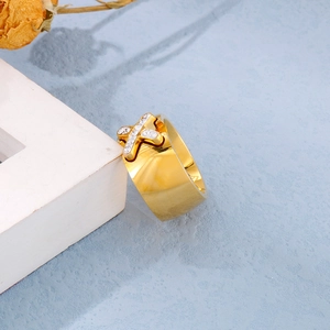 Detailed view of luxury gold-plated X-shape ring with pavé cubic zirconia on a blue background