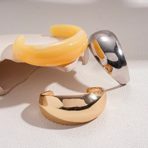 Minimalist chunky geometric open bangles in gold and silver finish on artistic display
