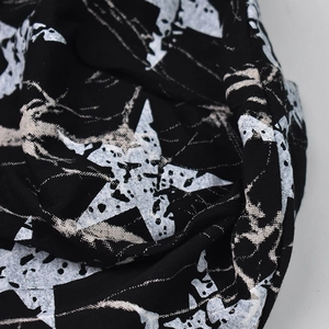 Gros plan sur la texture du tricot doux et l'imprimé étoile vintage du bonnet noir