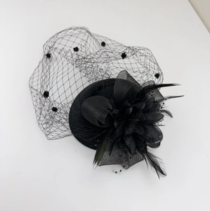Detail of black fascinator hat with polka dot mesh veil and elegant feather flower