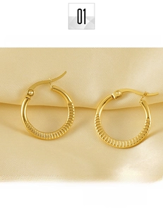 Detailed view of gold plated titanium steel hoop earrings with textured vertical grooves