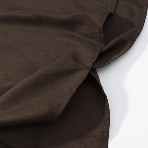 Detail of side slit on dark brown textured fabric with double-needle stitching