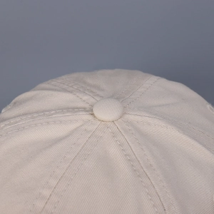 Primer plano detallado de la sarga de algodón y el botón de una gorra de béisbol beige