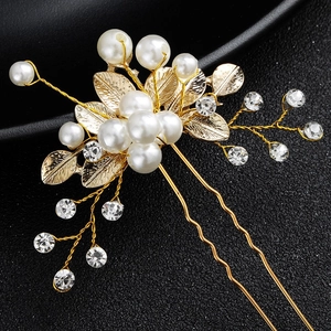 Detailed close-up of handmade bridal U-shaped hair pin with pearls and golden leaves