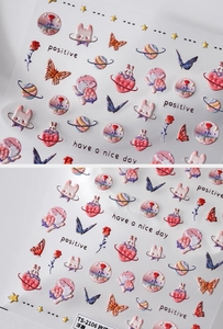 Détail macro de stickers ongles 3D en relief avec motifs de rose, planète et lapin