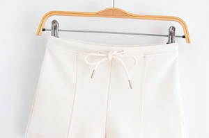 Detail of cream casual shorts with elastic waistband and metal-tipped drawstrings