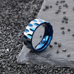 Men's silver steel ring with blue inner plating on textured stone background