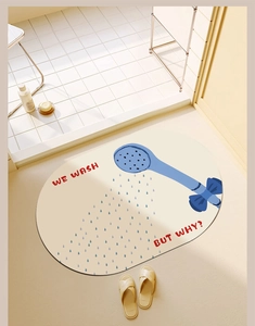 Close-up of oval bath mat with blue shower pattern and 'WE WASH BUT WHY?' text detail