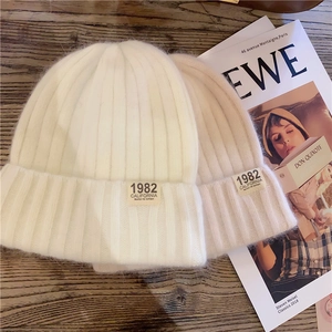 Close-up of knit beanies with 1982 California fabric patch on rustic wooden background