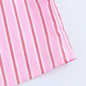 Close-up of pink and red striped shirt fabric showing fine texture and hem stitching