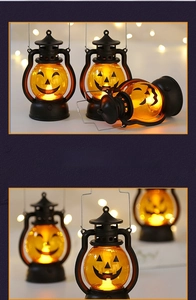 Detail of Halloween pumpkin LED lantern with warm glowing light and metal handle