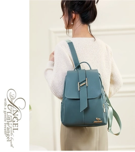 Detail of teal leather backpack showing magnetic flap and gold kangaroo logo on shoulder