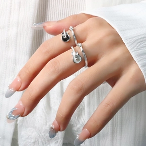 Close-up of silver guitar rings with black and white enamel on a hand